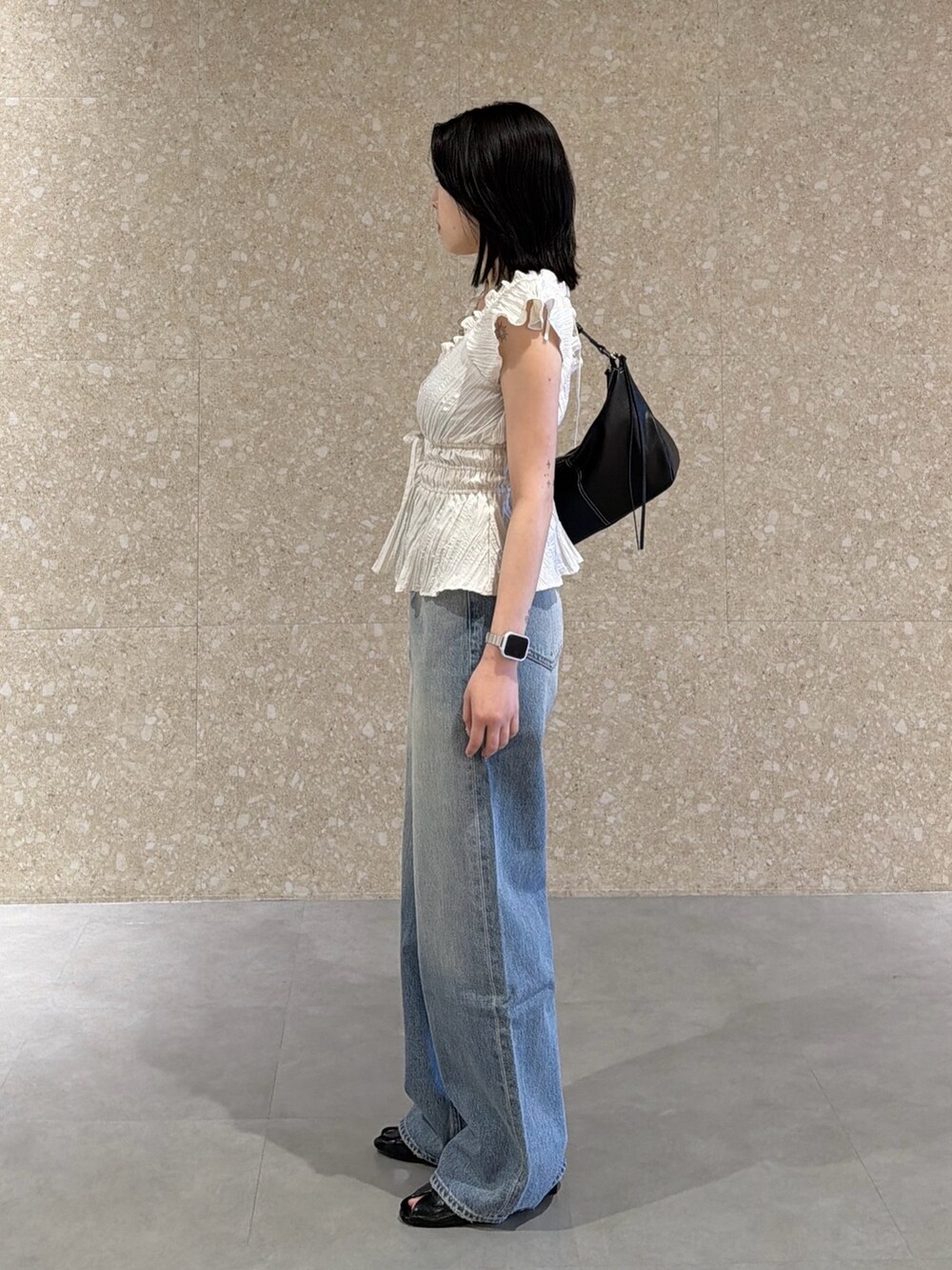ホワイト系のシャツ/ブラウス、ブルー系のデニムパンツ、ブラック系のサンダルを着用したレディースの春コーディネートの4枚目の写真