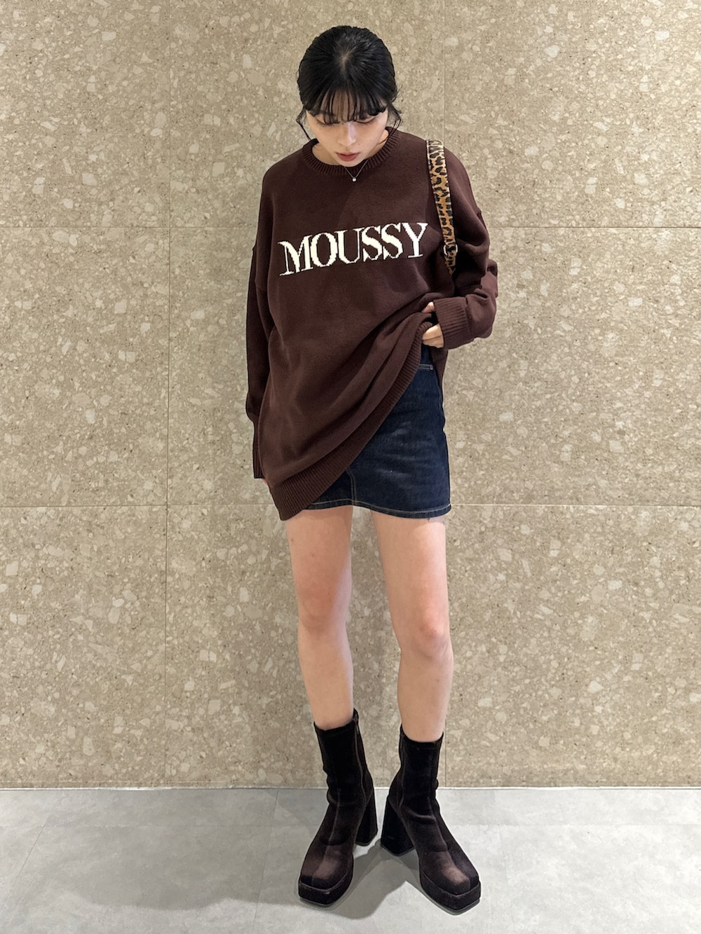 ブラウン系のニット/セーター、ブラウン系のブーツ、ブラウン系のハンドバッグを着用したレディースの秋コーディネートの2枚目の写真