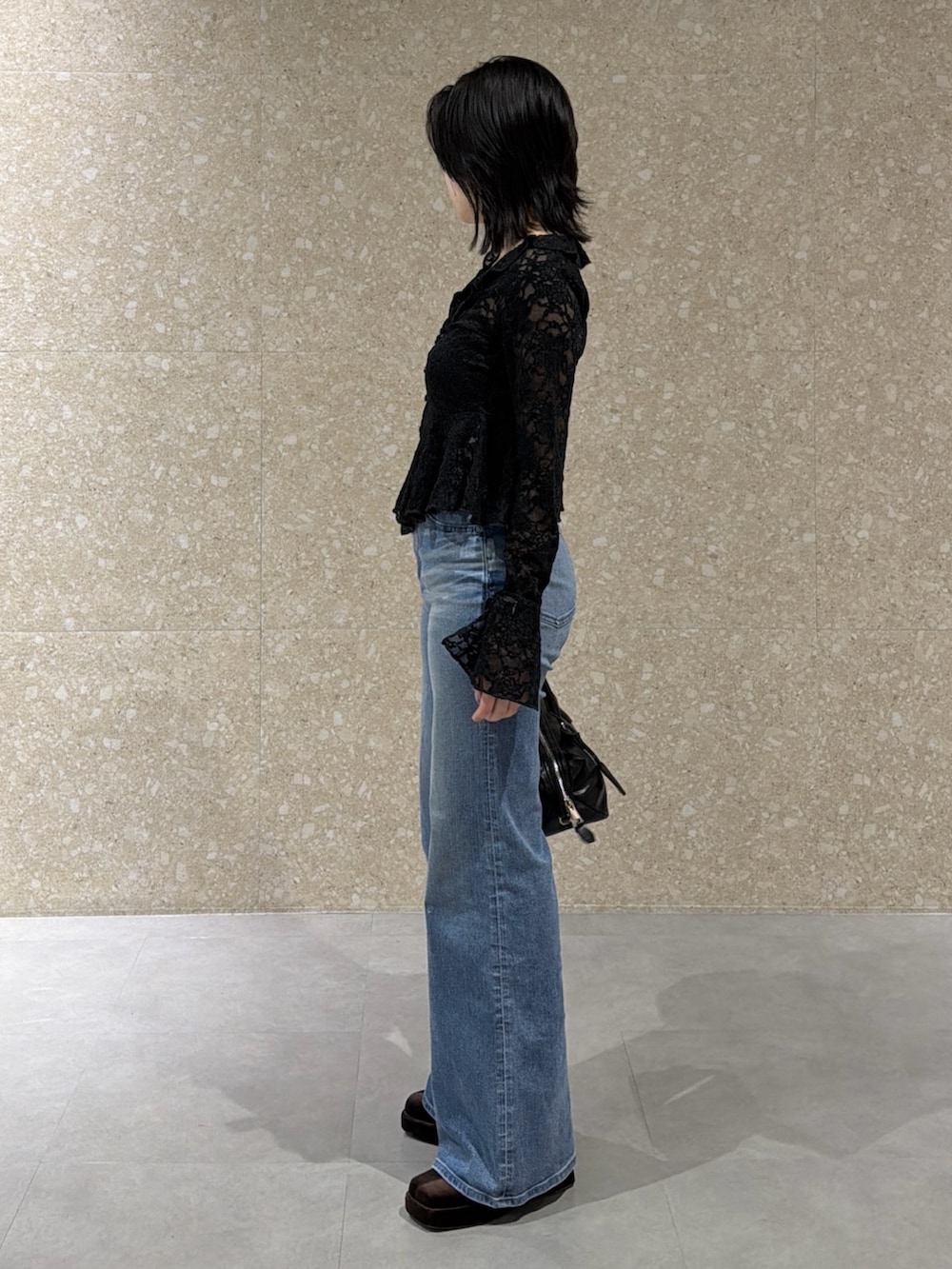 ブラック系のTシャツ/カットソー、ブルー系のデニムパンツ、ブラック系のショルダーバッグを着用したレディースの冬コーディネートの2枚目の写真