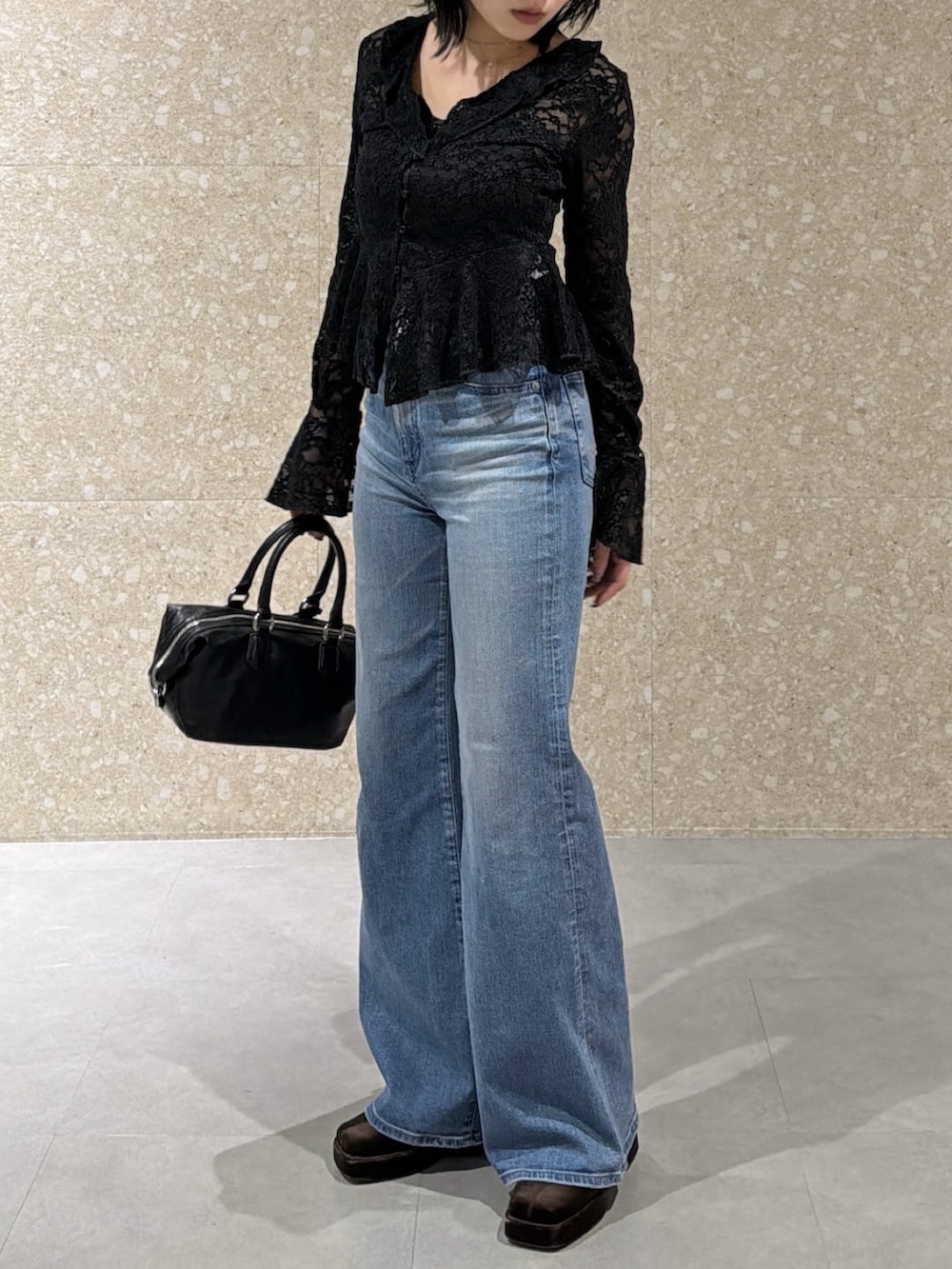 ブラック系のTシャツ/カットソー、ブルー系のデニムパンツ、ブラック系のショルダーバッグを着用したレディースの冬コーディネートの3枚目の写真