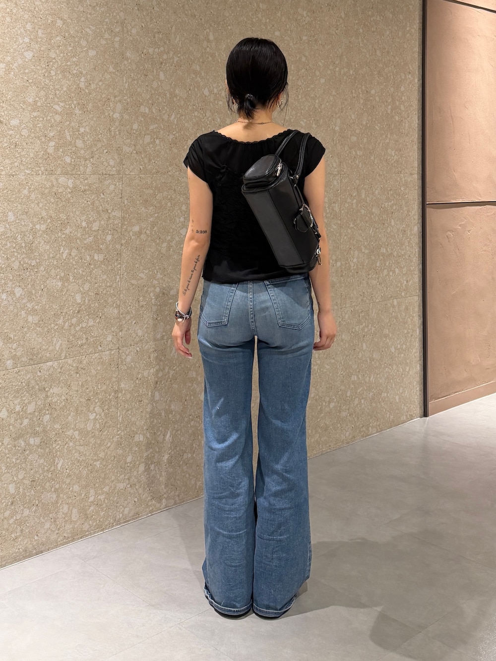 ブラック系のTシャツ/カットソー、ブルー系のデニムパンツ、ブラック系のブーツを着用したレディースの夏コーディネートの4枚目の写真