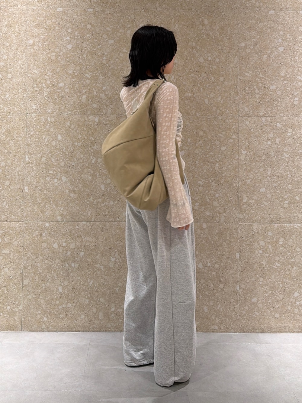 グレー系のスウェットパンツ、ホワイト系のシャツ/ブラウス、ベージュ系のショルダーバッグを着用したレディースの春コーディネートの4枚目の写真