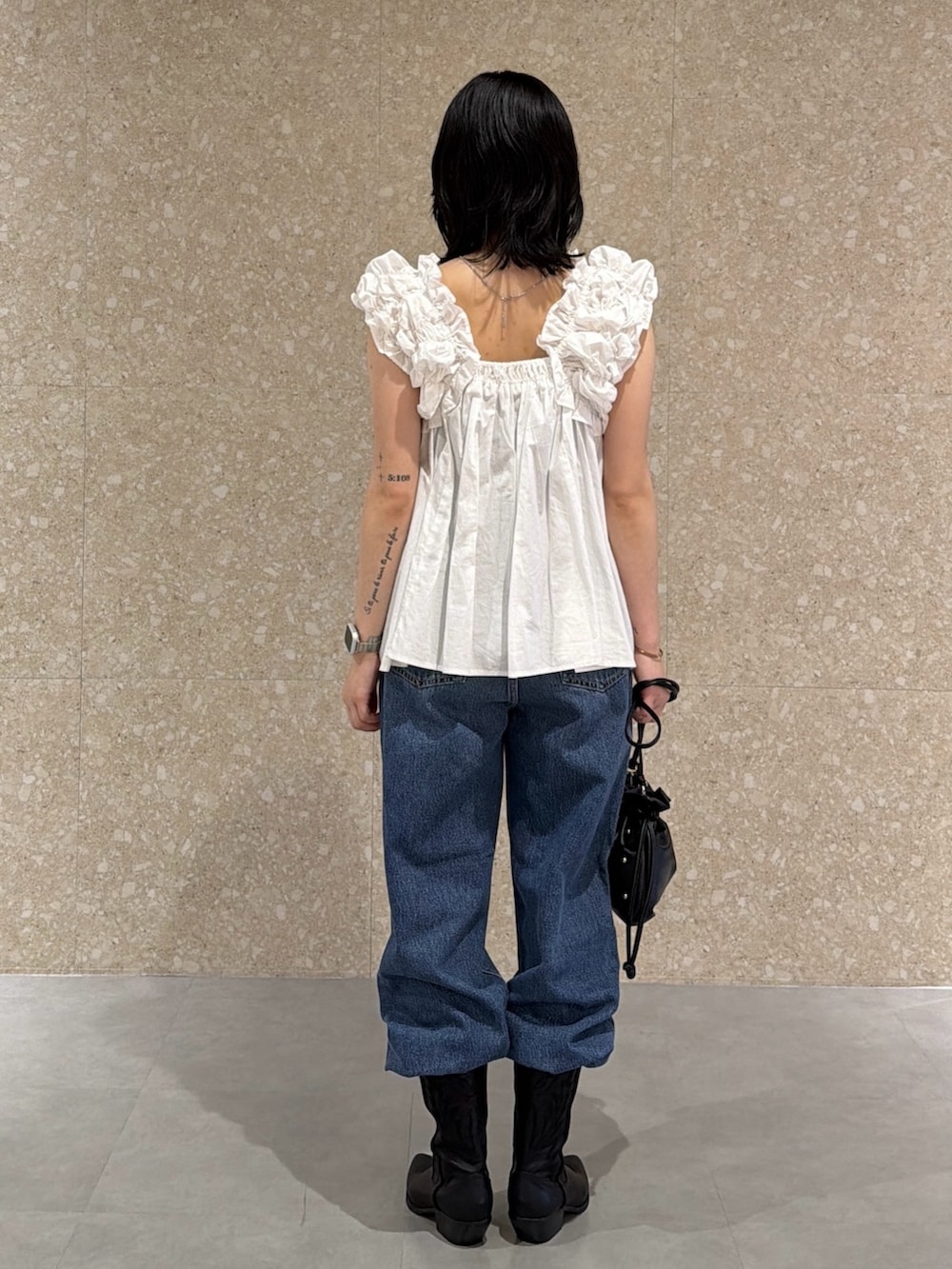 ホワイト系のシャツ/ブラウス、ブルー系のデニムパンツ、ブラック系のブーツを着用したレディースの夏コーディネートの3枚目の写真