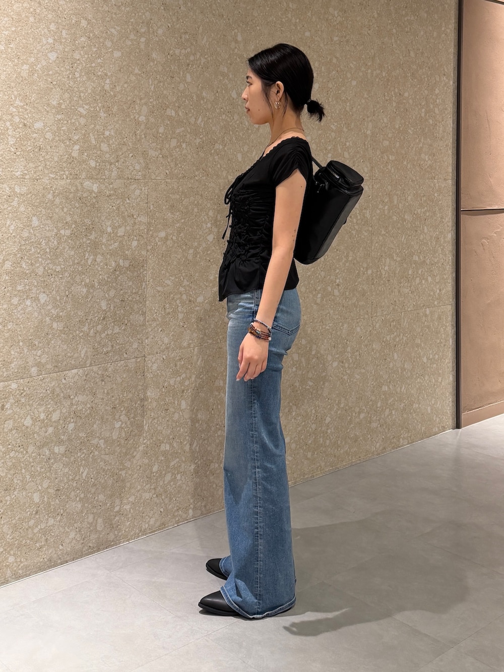ブラック系のTシャツ/カットソー、ブルー系のデニムパンツ、ブラック系のブーツを着用したレディースの夏コーディネートの3枚目の写真