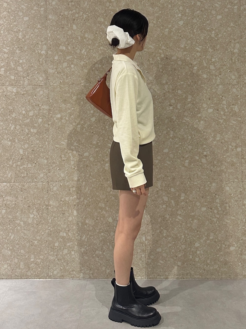 ホワイト系のTシャツ/カットソー、ブラウン系のその他パンツ、ブラック系のブーツを着用したレディースの秋コーディネートの3枚目の写真