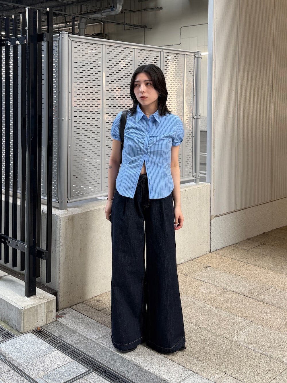 ブルー系のデニムパンツ、ブルー系のシャツ/ブラウス、ブラック系のショルダーバッグを着用したレディースの春コーディネートの2枚目の写真