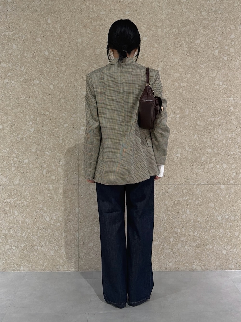 ベージュ系のその他アウター、ホワイト系のニット/セーター、ブルー系のデニムパンツを着用したレディースの秋コーディネートの4枚目の写真