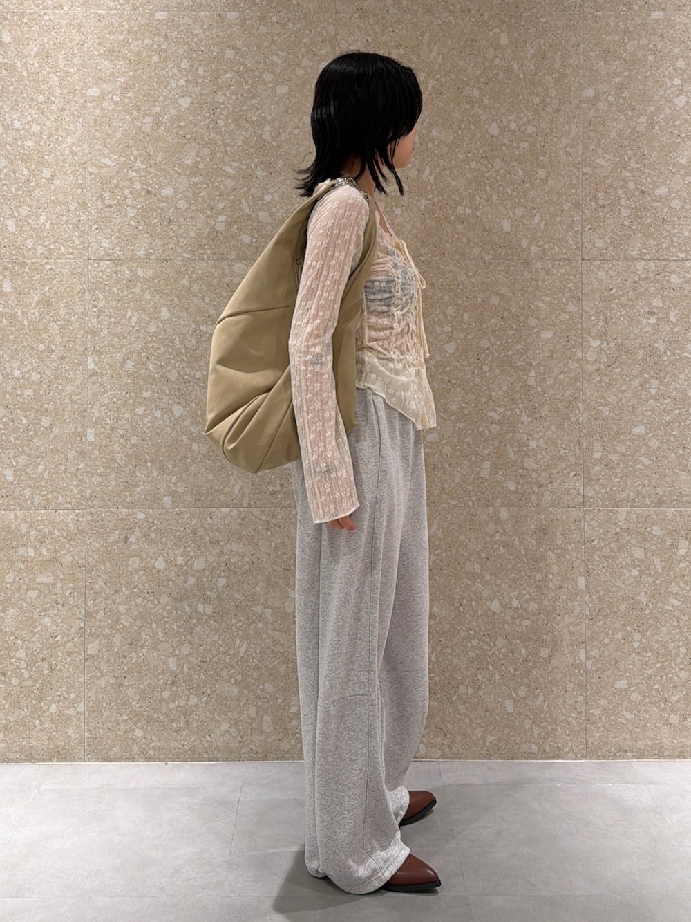 グレー系のスウェットパンツ、ホワイト系のシャツ/ブラウス、ベージュ系のショルダーバッグを着用したレディースの春コーディネートの3枚目の写真