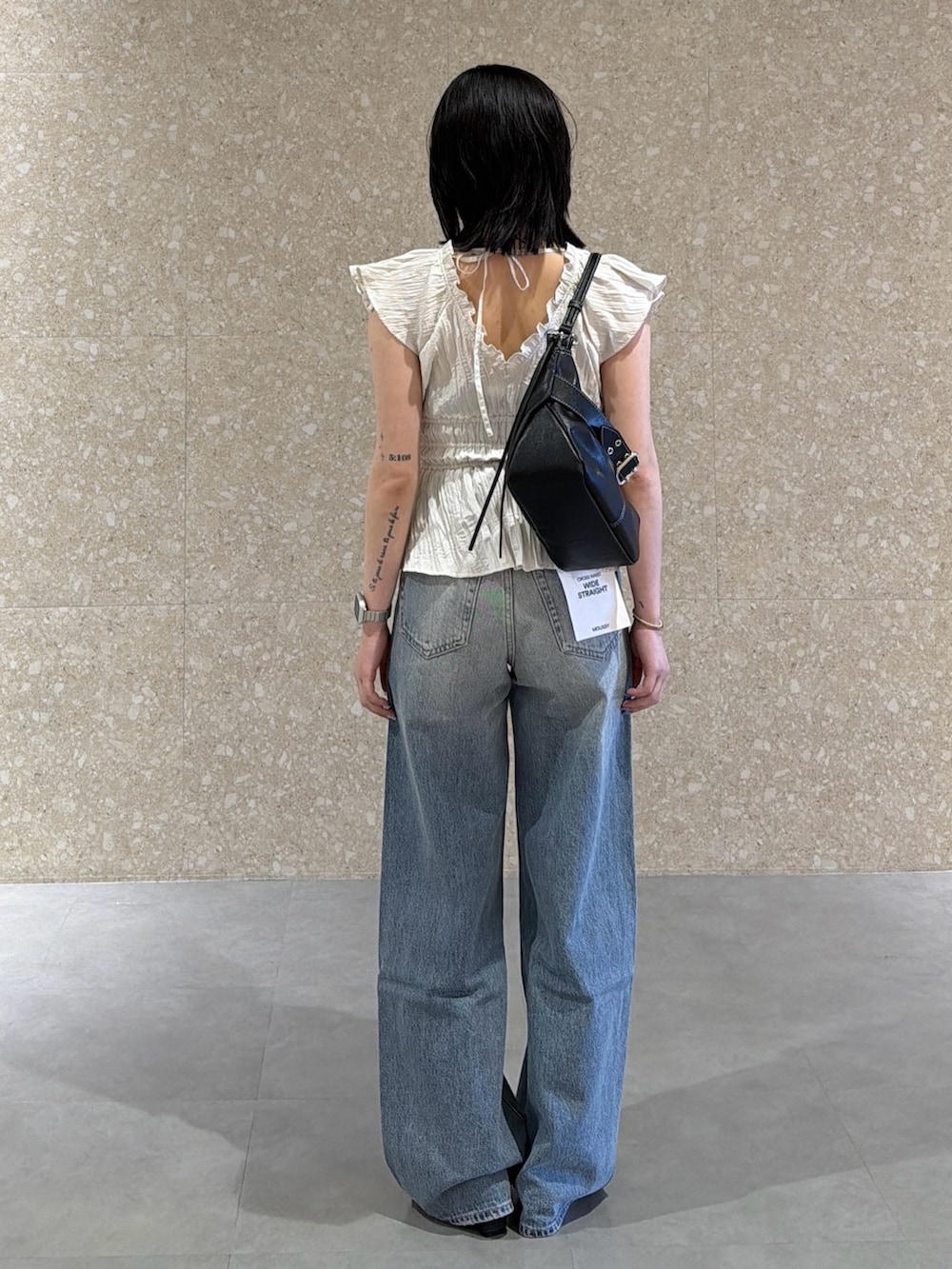 ホワイト系のシャツ/ブラウス、ブルー系のデニムパンツ、ブラック系のサンダルを着用したレディースの春コーディネートの3枚目の写真