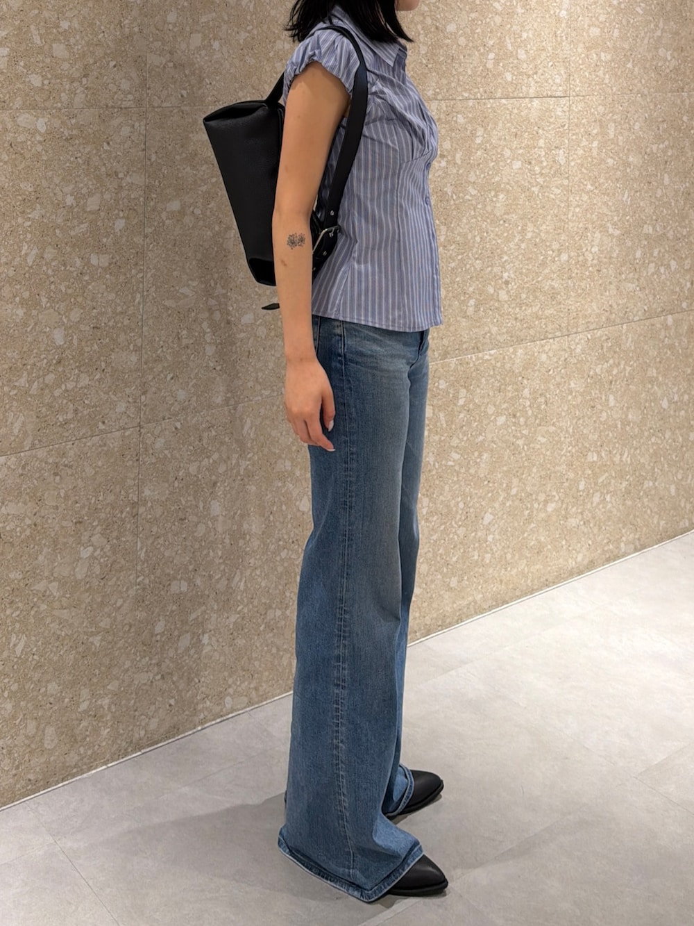 ブルー系のシャツ/ブラウス、ブルー系のデニムパンツ、ブラック系のブーツを着用したレディースの夏コーディネートの3枚目の写真
