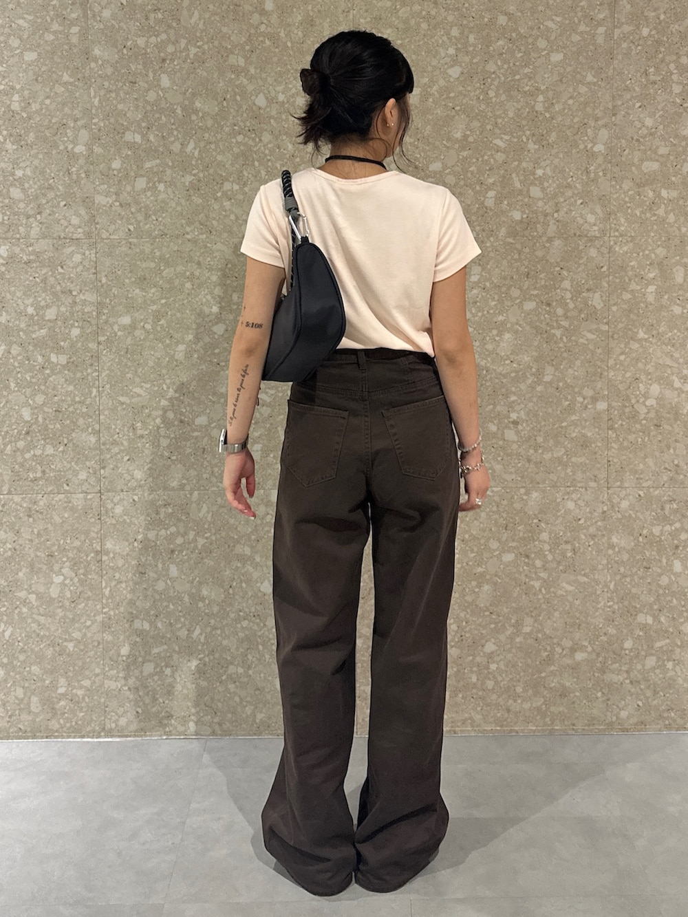 ブラウン系のチノパンツ、ブラック系のブーツ、オレンジ系のTシャツ/カットソーを着用したレディースの夏コーディネートの3枚目の写真