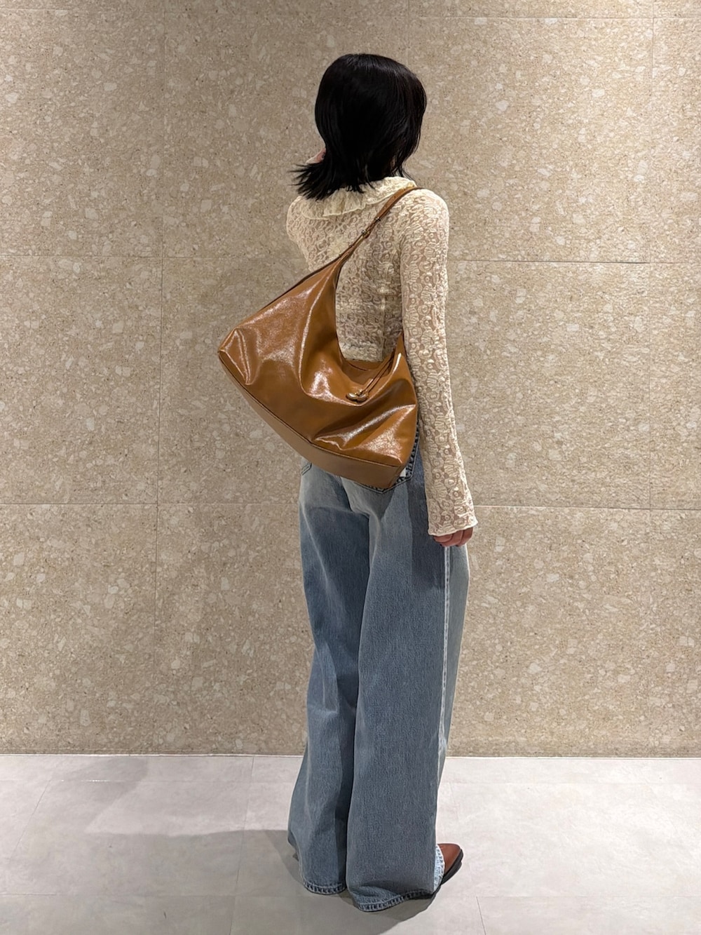 ホワイト系のシャツ/ブラウス、ブルー系のデニムパンツ、ブラウン系のブーツを着用したレディースの春コーディネートの4枚目の写真