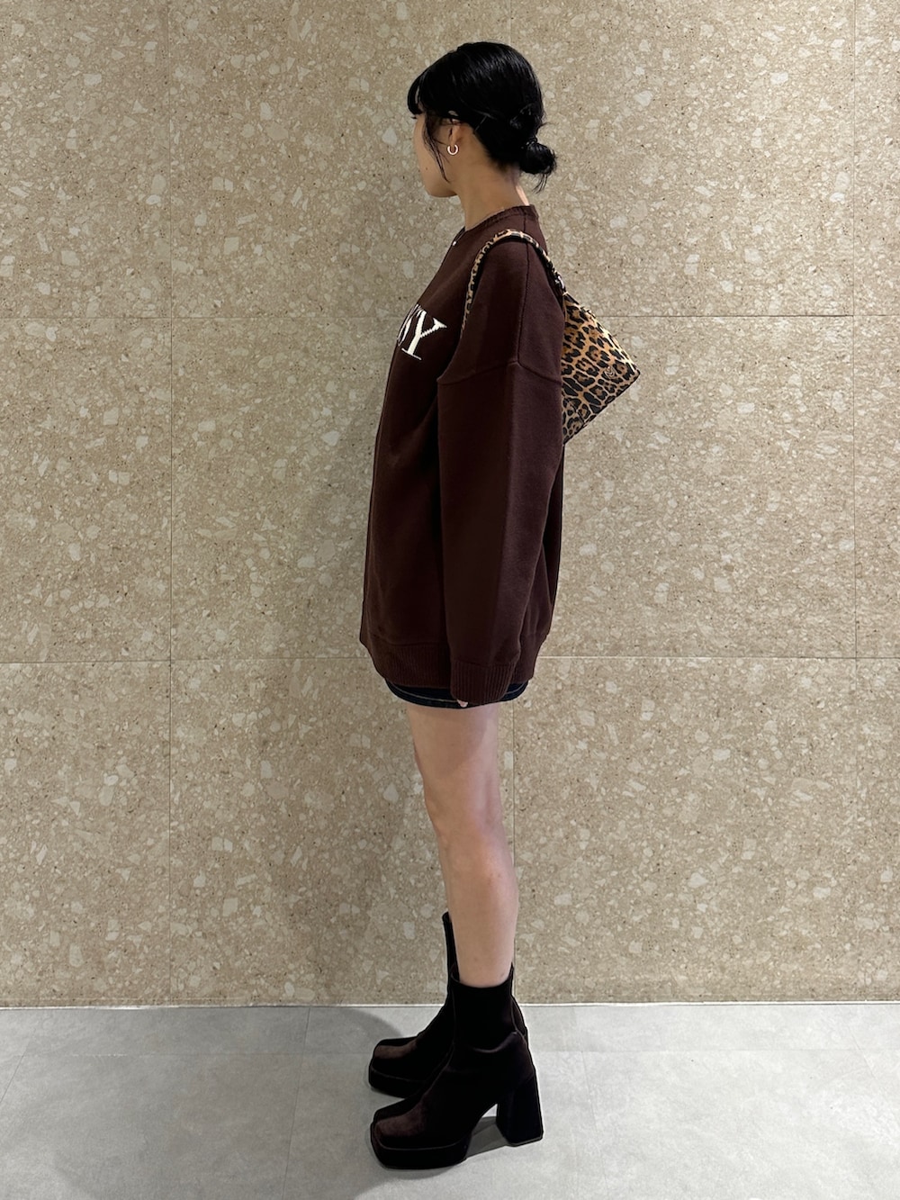 ブラウン系のニット/セーター、ブラウン系のブーツ、ブラウン系のハンドバッグを着用したレディースの秋コーディネートの4枚目の写真