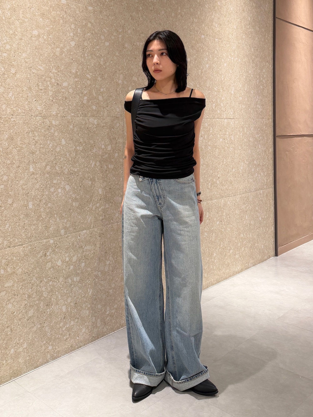ブルー系のデニムパンツ、ブラック系のブーツ、ブラック系のTシャツ/カットソーを着用したレディースの夏コーディネートの2枚目の写真