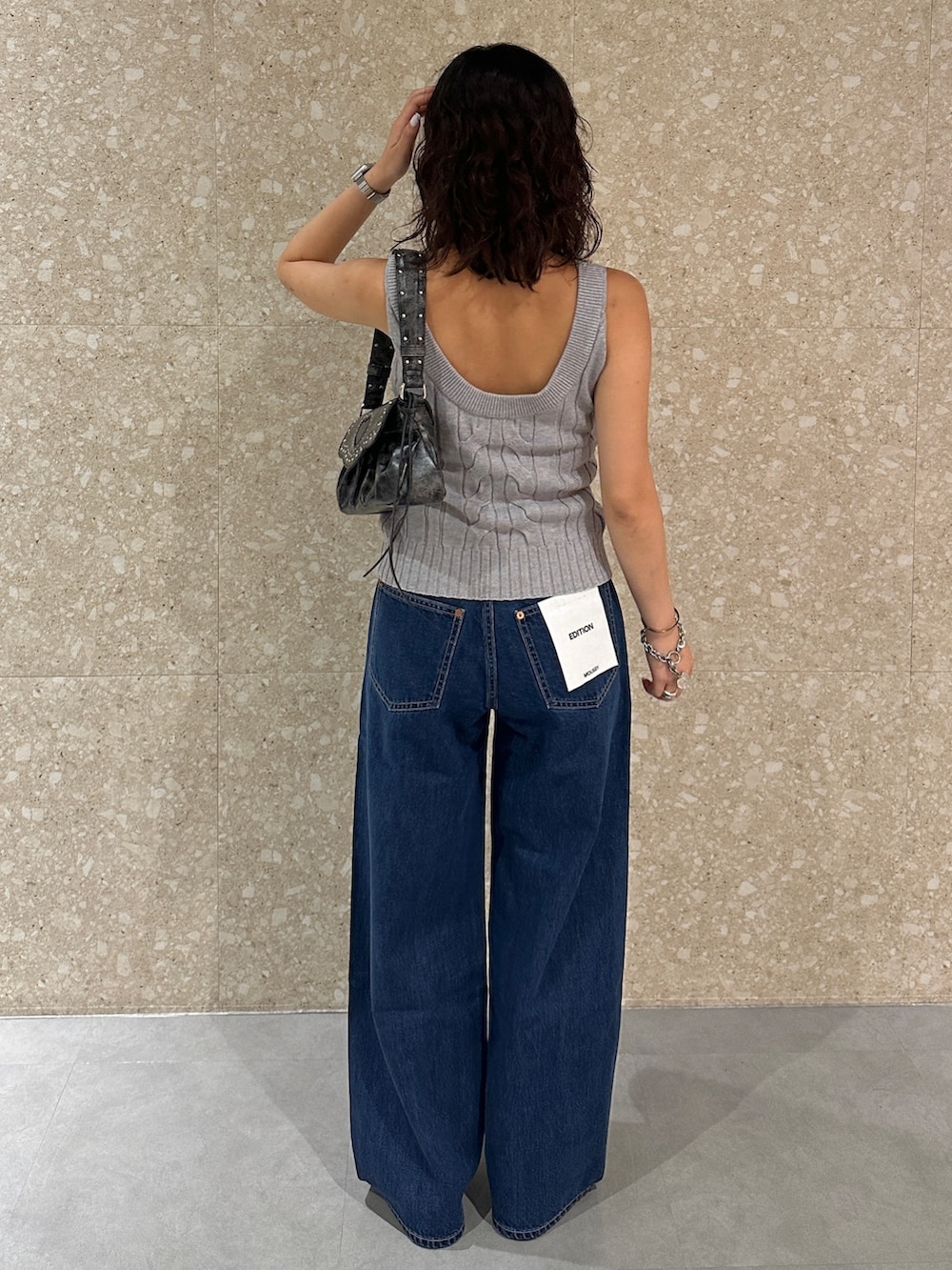 ブルー系のデニムパンツ、グレー系のキャミソール、ブラック系のショルダーバッグを着用したレディースの夏コーディネートの3枚目の写真