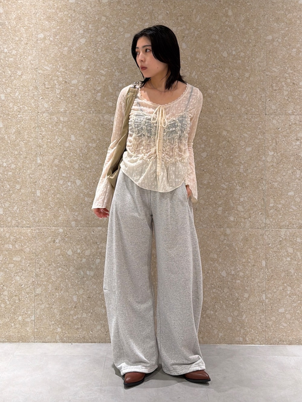 グレー系のスウェットパンツ、ホワイト系のシャツ/ブラウス、ベージュ系のショルダーバッグを着用したレディースの春コーディネートの2枚目の写真