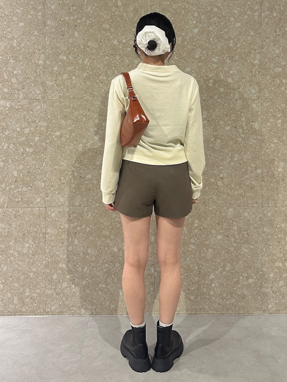 ホワイト系のTシャツ/カットソー、ブラウン系のその他パンツ、ブラック系のブーツを着用したレディースの秋コーディネートの4枚目の写真