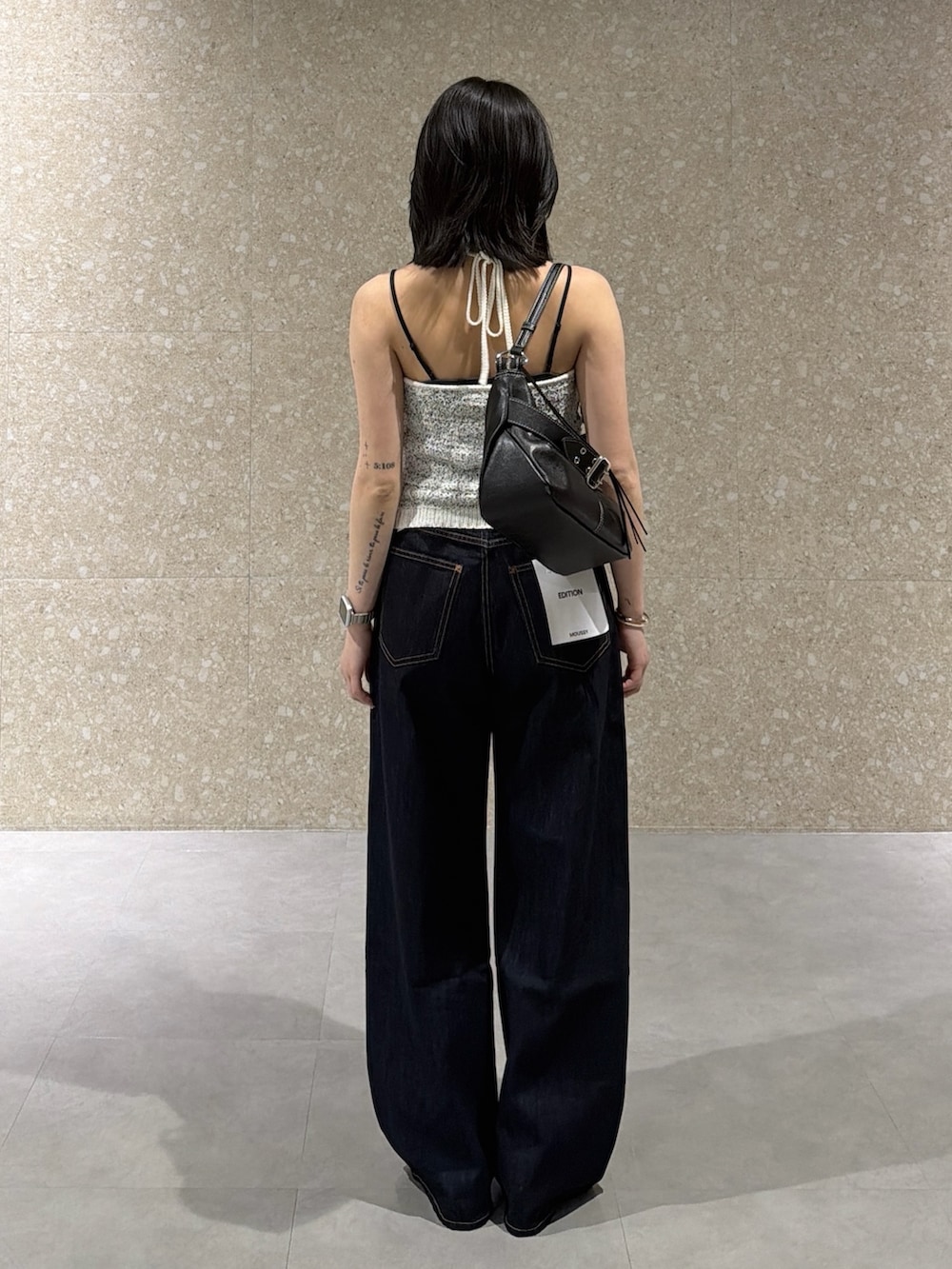 ホワイト系のキャミソール、ブルー系のデニムパンツ、ブラック系のサンダルを着用したレディースの春コーディネートの3枚目の写真