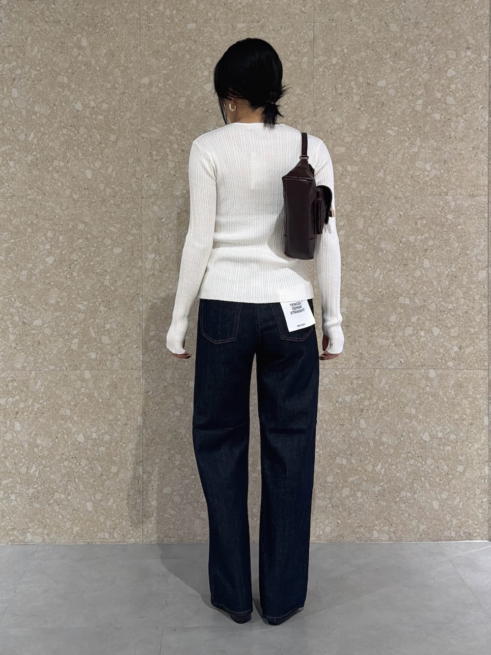 ホワイト系のニット/セーター、ブルー系のデニムパンツ、レッド系のパンプスを着用したレディースの秋コーディネートの3枚目の写真