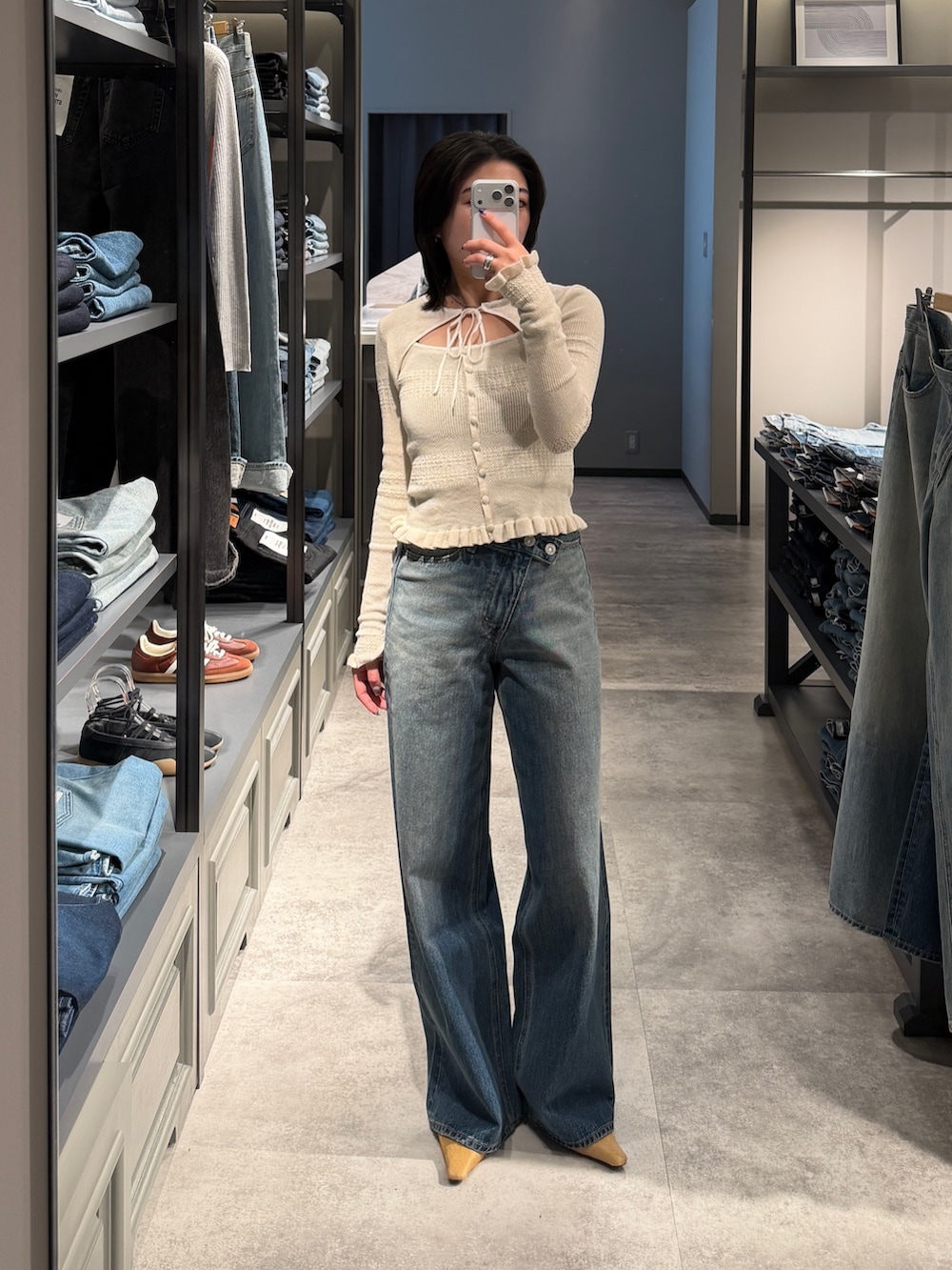 ホワイト系のニット/セーター、ブルー系のデニムパンツ、ベージュ系のサンダルを着用したレディースの春コーディネートの5枚目の写真