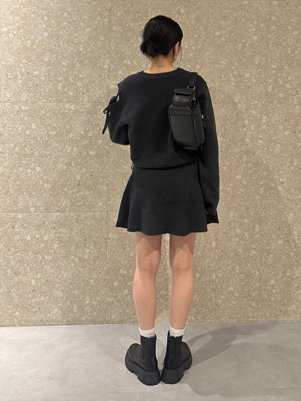 グレー系のワンピース、ブラック系のブーツ、ブラック系のショルダーバッグを着用したレディースの秋コーディネートの3枚目の写真