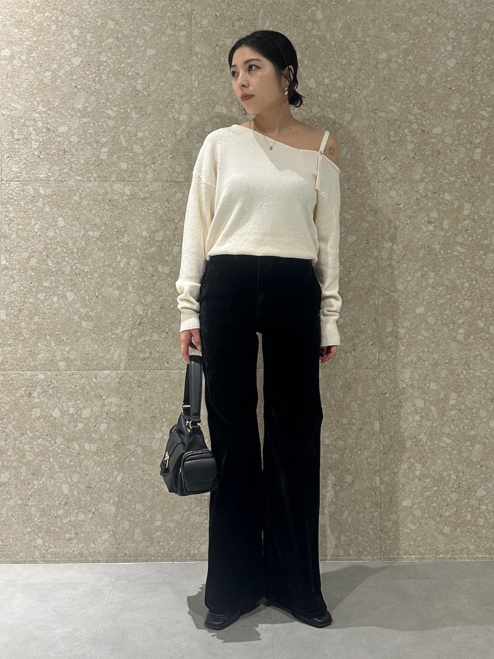 ブラック系のデニムパンツ、ブラック系のローファー、ブラック系のショルダーバッグを着用したレディースの秋コーディネートの2枚目の写真