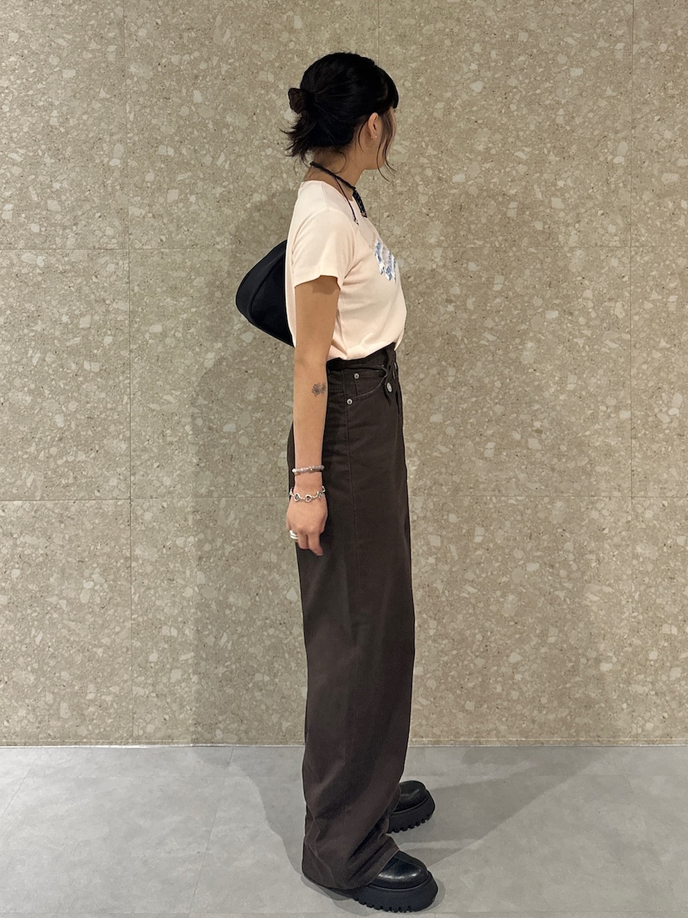 ブラウン系のチノパンツ、ブラック系のブーツ、オレンジ系のTシャツ/カットソーを着用したレディースの夏コーディネートの5枚目の写真