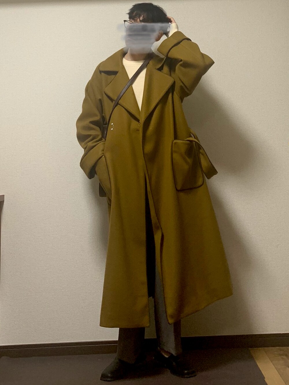 イエロー系のチェスターコート、ブラウン系のスラックス、ブラック系のローファーを着用したメンズの秋コーディネートの2枚目の写真