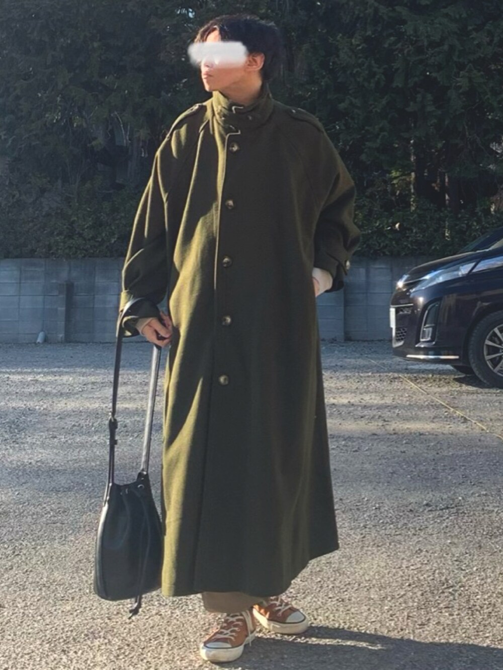 グリーン系のステンカラーコート、ベージュ系のスウェット、ベージュ系のカーゴパンツを着用したメンズの冬コーディネートの2枚目の写真