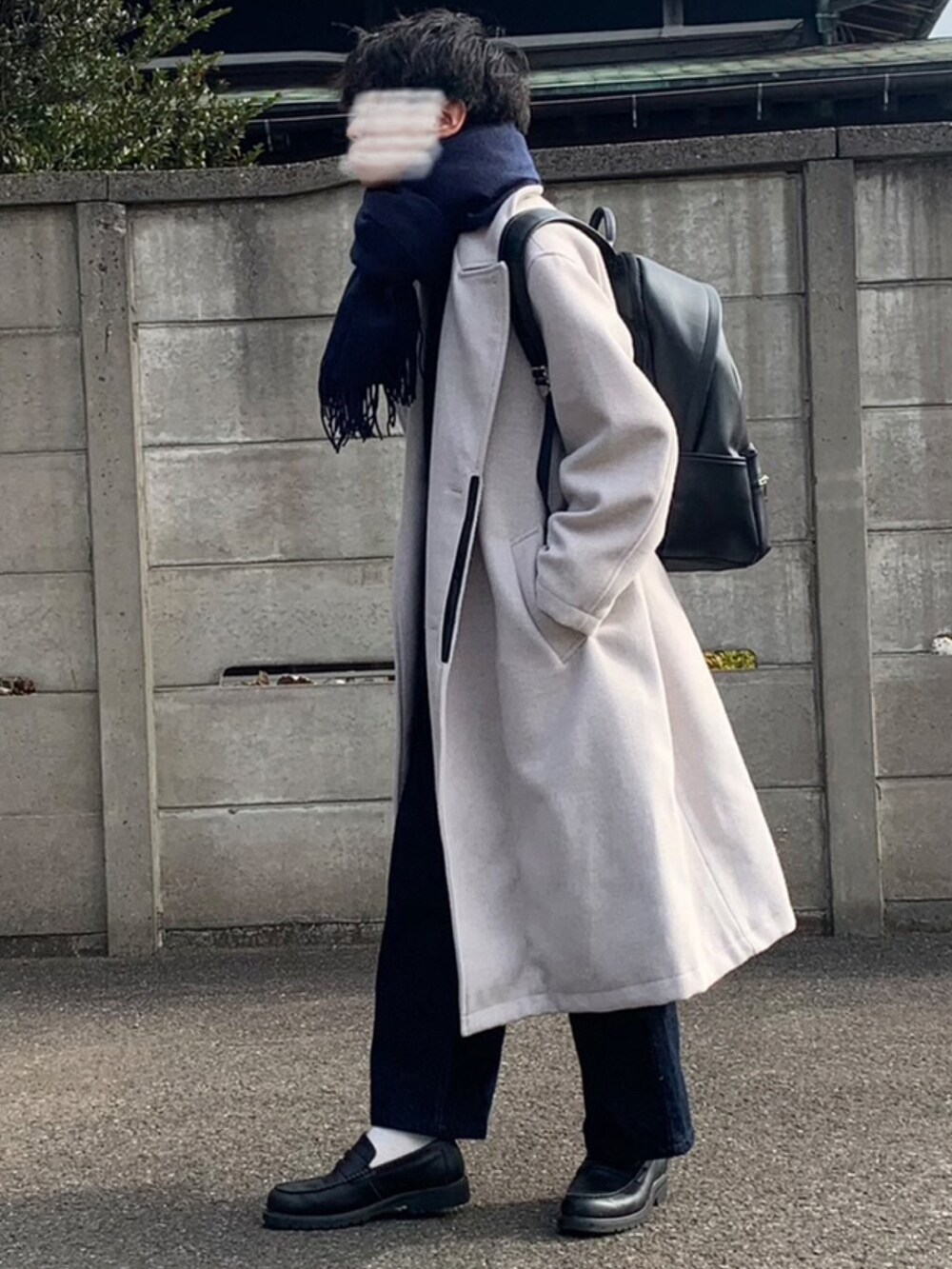 ホワイト系のチェスターコート、ブルー系のデニムパンツ、ブラック系のローファーを着用したメンズの冬コーディネートの2枚目の写真