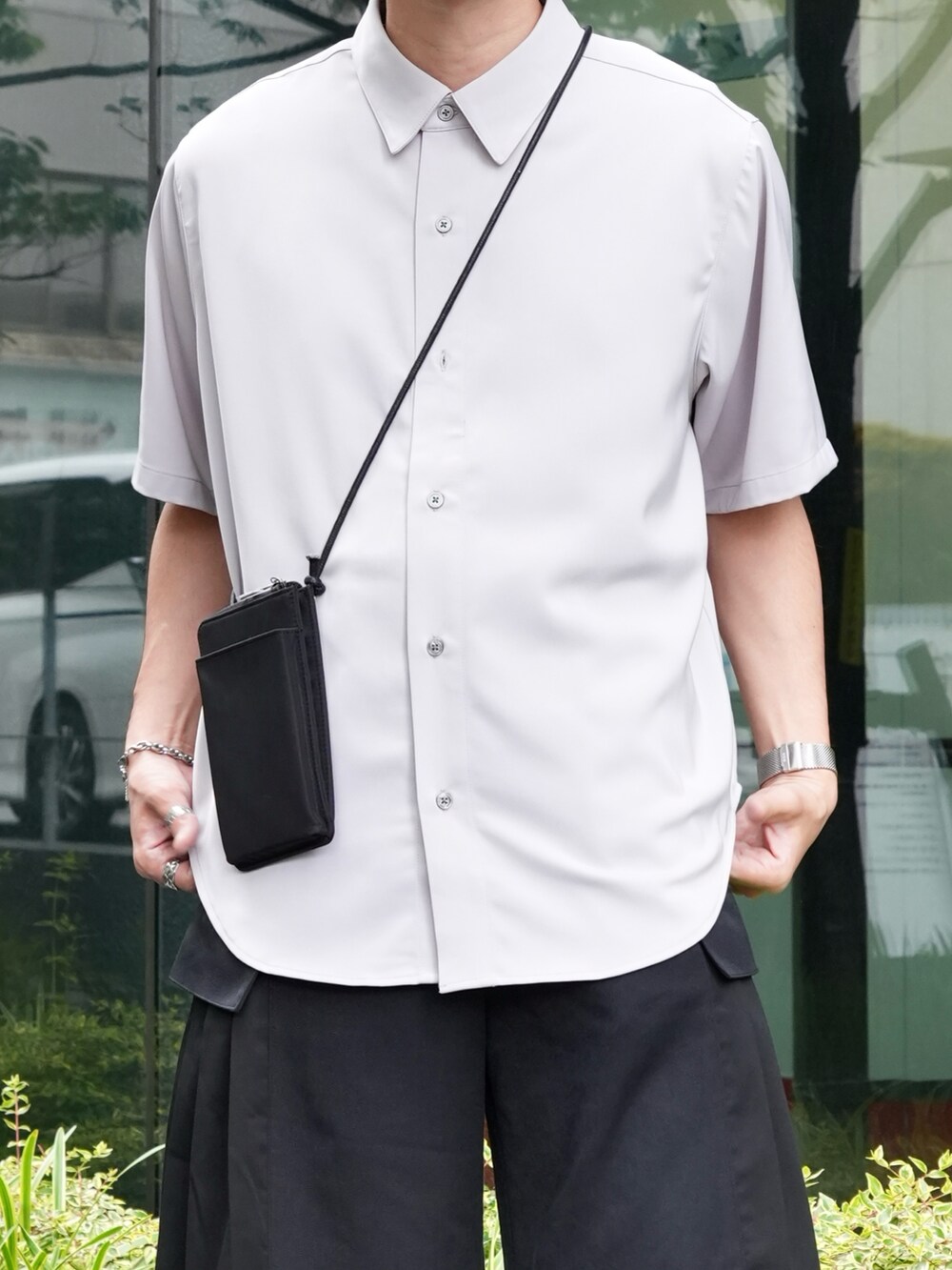 グレー系のシャツ/ブラウス、ブラック系のショルダーバッグ、ブラック系のスラックスを着用したメンズの春コーディネートの2枚目の写真