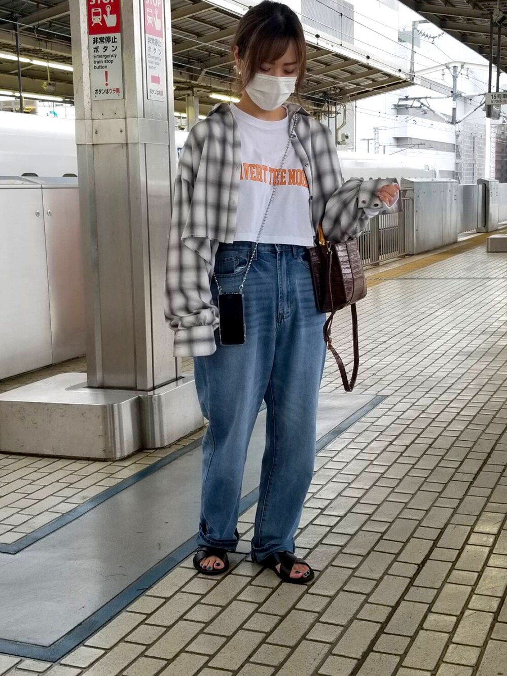 グレー系のトップス、ホワイト系のトップス、ブルー系のデニムパンツを着用したレディースの秋コーディネートの2枚目の写真