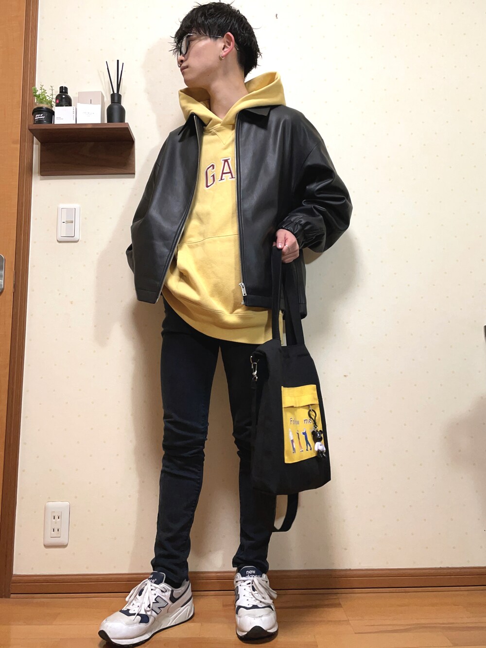 ブラック系のブルゾン、イエロー系のパーカー、ブラック系のパンツを着用したメンズの春コーディネートの3枚目の写真