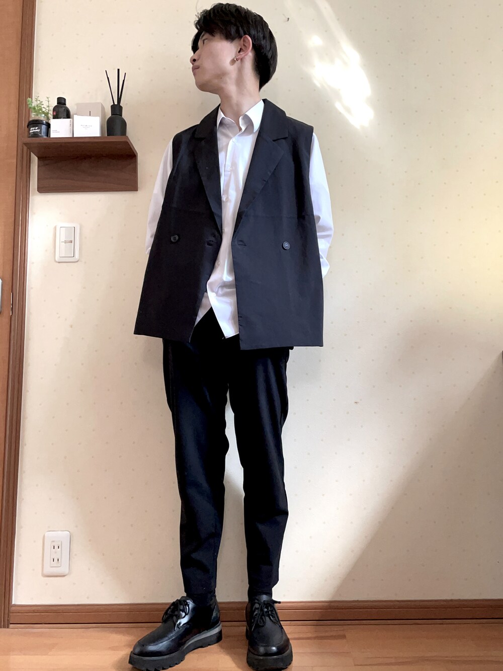 ブラック系のベスト、ホワイト系のシャツ/ブラウス、ブラック系のパンツを着用したメンズの春コーディネートの3枚目の写真