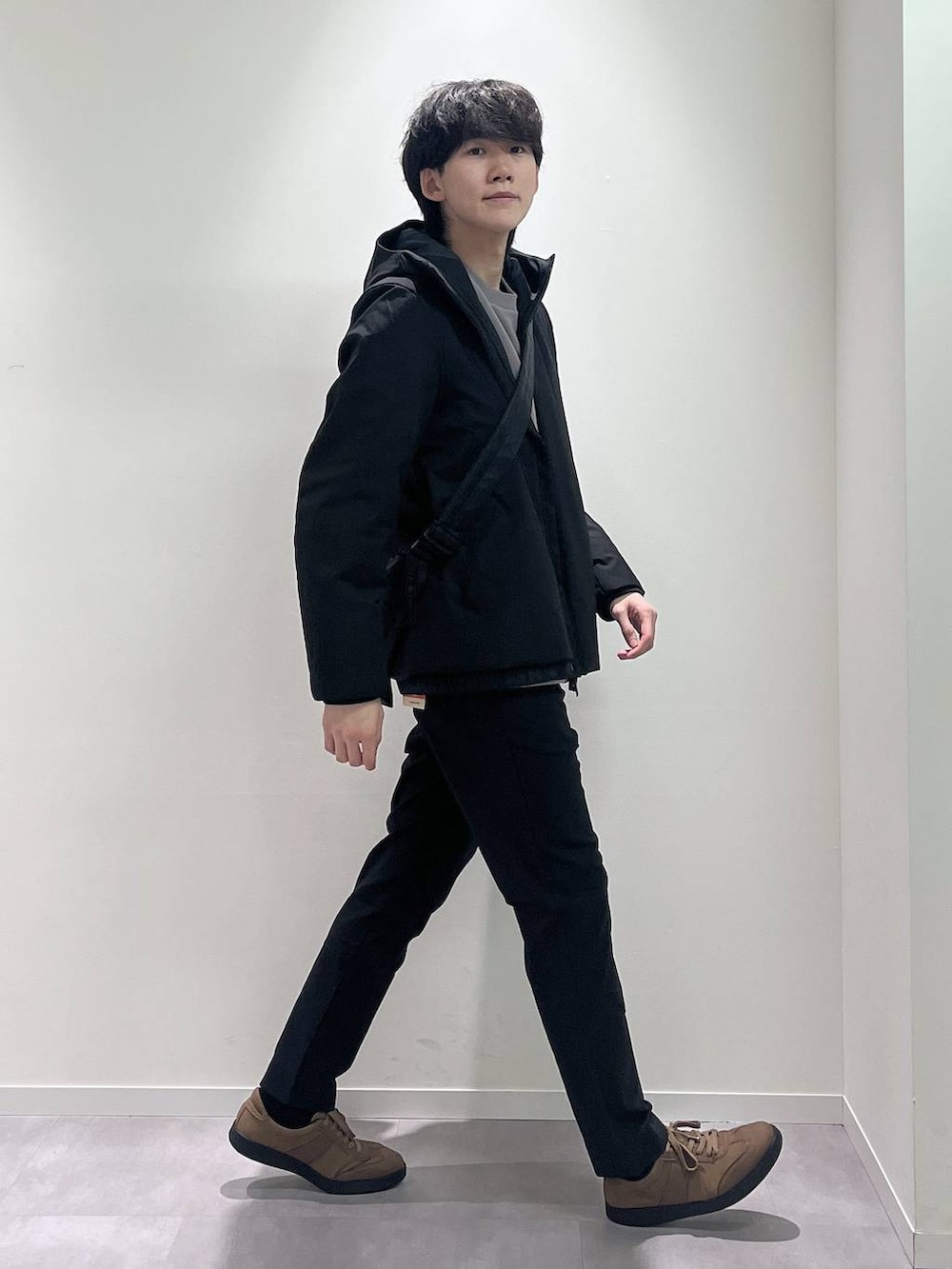 ブラウン系のスニーカー、ブラック系のショルダーバッグ、ブラック系のブルゾンを着用したメンズの秋コーディネートの2枚目の写真