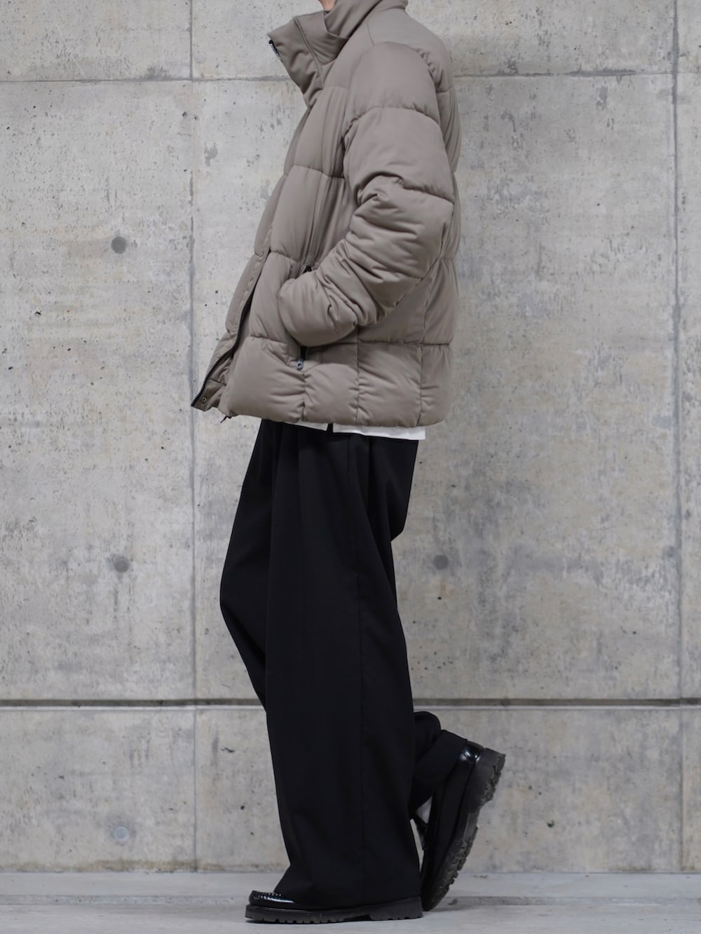 ブラック系のスラックス、ベージュ系のブルゾンを着用したメンズの秋コーディネートの3枚目の写真