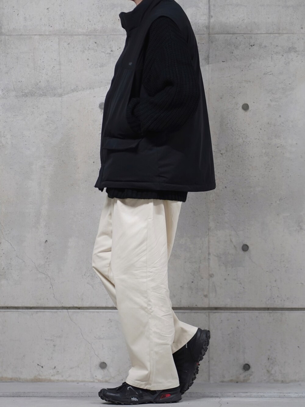 「ベスト、ダウンベスト、白パンツ、ワイドパンツ、モノトーン、モノトーンコーデ、スニーカー、スニーカーコーデ、ニット、冬コーデ、休日スタイル、お洒落さんとつながりたい、今日のコーデ、プチプラコーデ、シンプルコーデ」｜「MONO-MARTの【retock's】ロゴ刺繍 スタンドカラーボリュームモンスターパディングベスト（ダウンベスト、ブラック系）」を使った、なおゑさん（メンズ・180cm）の冬コーディネートの2枚目の写真