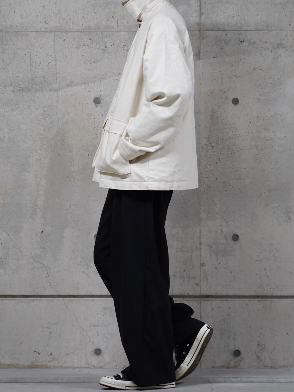 ホワイト系のブルゾン、ブラック系のスラックスを着用したメンズの冬コーディネートの2枚目の写真