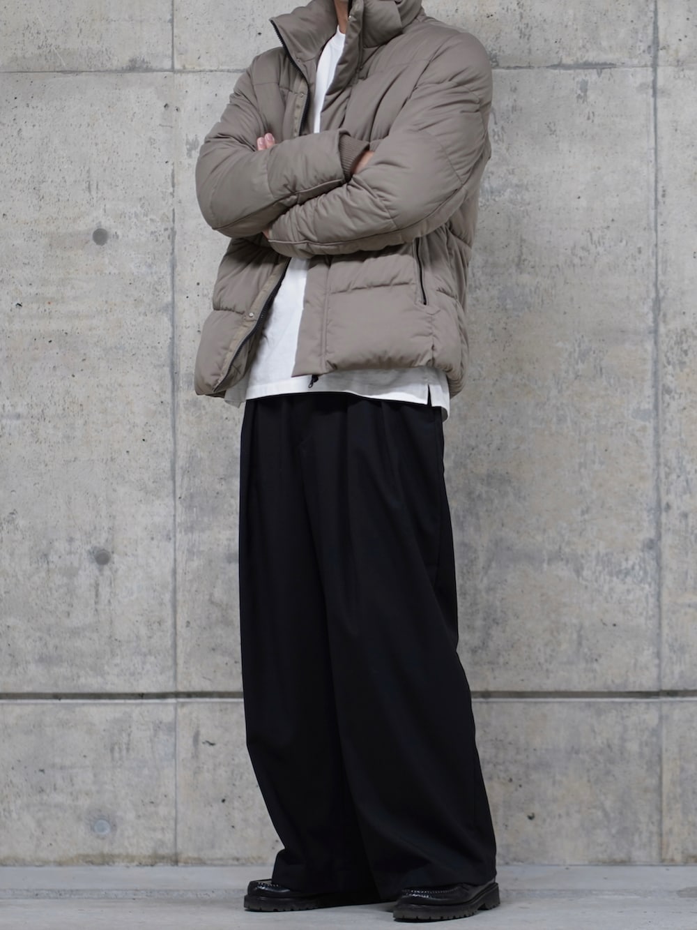 ブラック系のスラックス、ベージュ系のブルゾンを着用したメンズの秋コーディネートの2枚目の写真