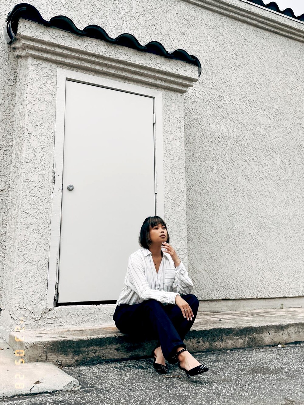 ブルー系のデニムパンツ、ブラック系のパンプスを着用したレディースの春コーディネートの5枚目の写真