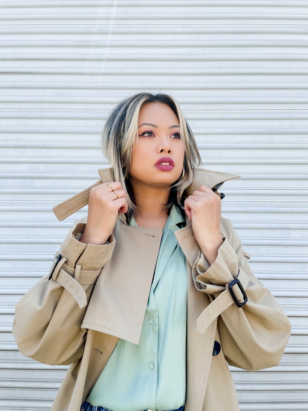 ベージュ系のトレンチコート、ブラウン系のショルダーバッグを着用したレディースの春コーディネートの2枚目の写真