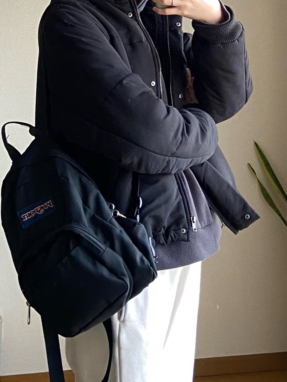 ブラック系のその他アウター、ブラック系のパーカー、ホワイト系のスウェットパンツを着用したレディースの冬コーディネートの2枚目の写真