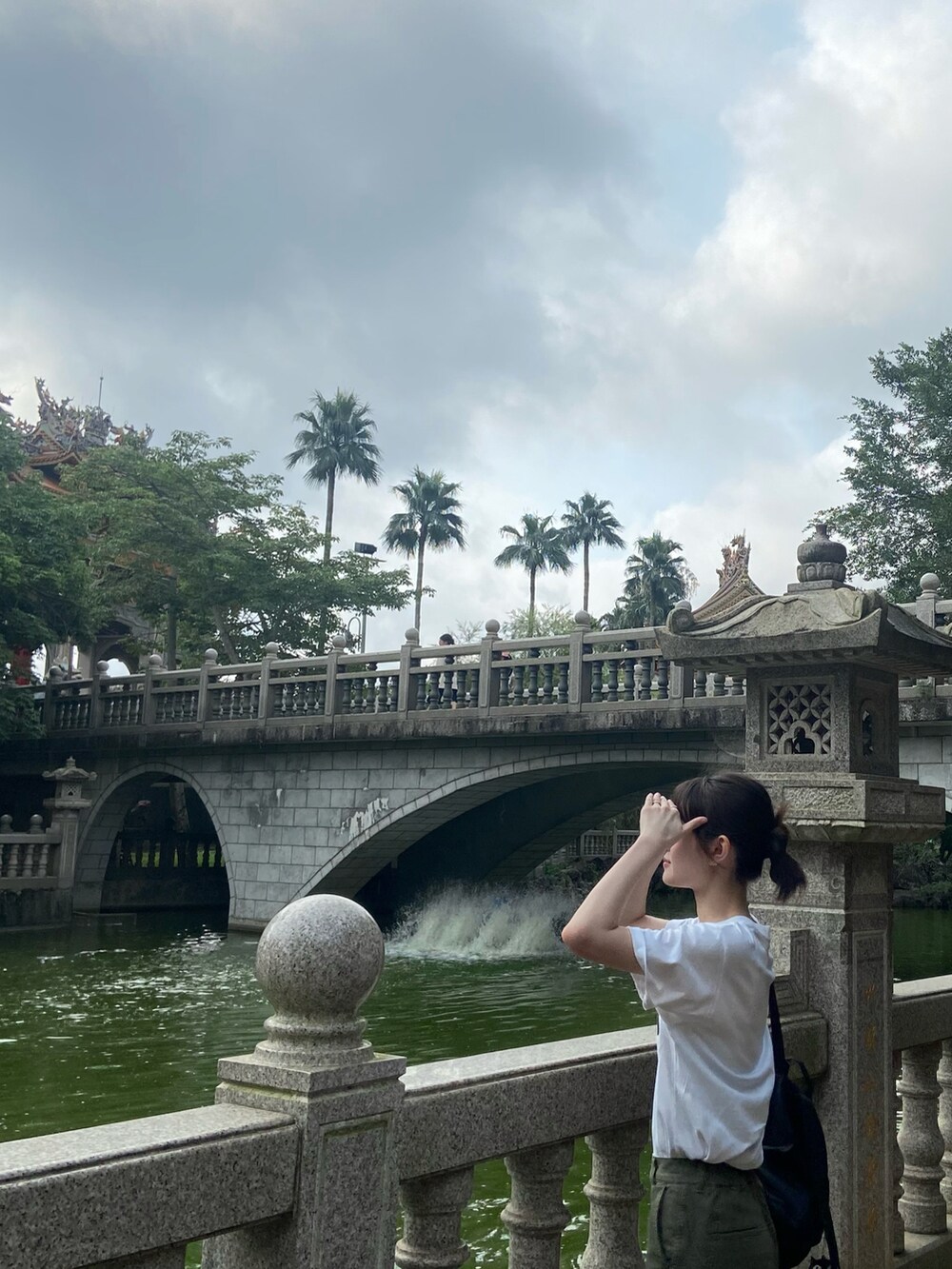 グリーン系のチノパンツ、ホワイト系のTシャツ/カットソー、ブラック系のバックパック/リュックを着用したレディースの夏コーディネートの3枚目の写真