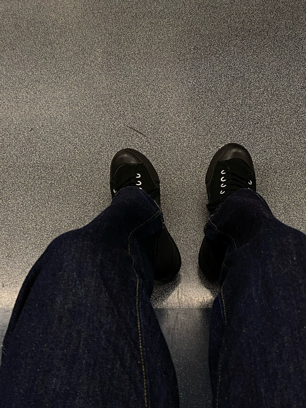 ブラック系のニット/セーター、ブルー系のデニムパンツ、ブラック系のスニーカーを着用したレディースの冬コーディネートの2枚目の写真