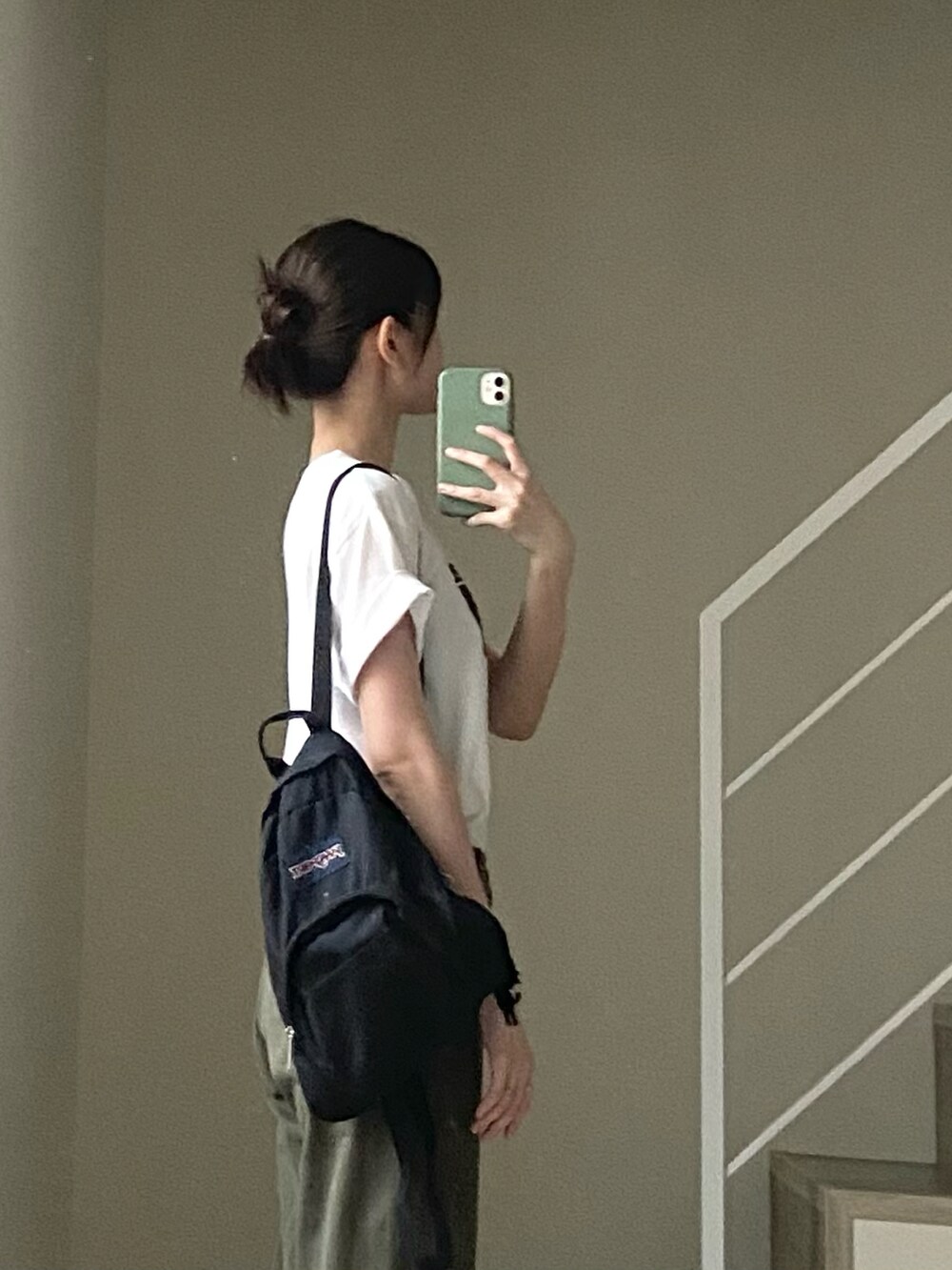 グリーン系のチノパンツ、ホワイト系のTシャツ/カットソー、ブラック系のバックパック/リュックを着用したレディースの夏コーディネートの2枚目の写真