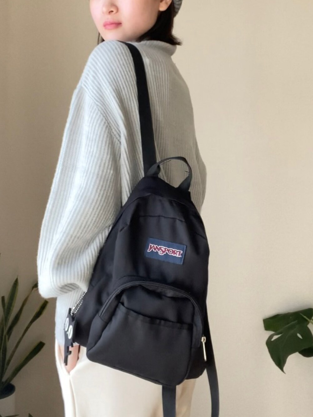 ホワイト系のスウェットパンツ、ブラック系のバックパック/リュック、グレー系のニット/セーターを着用したレディースの秋コーディネートの2枚目の写真