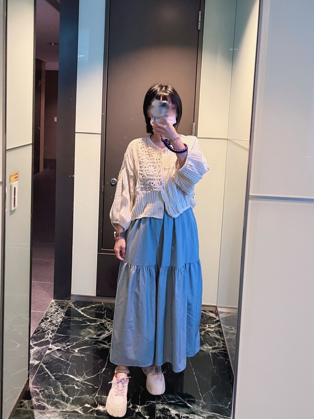 ブルー系のワンピース、ホワイト系のスニーカー、ホワイト系のブルゾンを着用したレディースの冬コーディネートの2枚目の写真