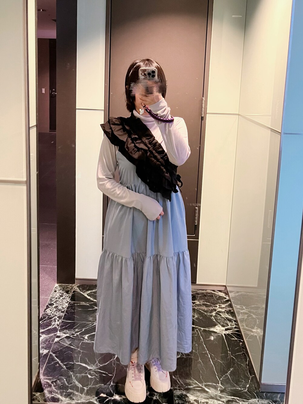 ホワイト系のスニーカー、ブルー系のワンピース、グレー系のトップスを着用したレディースの冬コーディネートの2枚目の写真