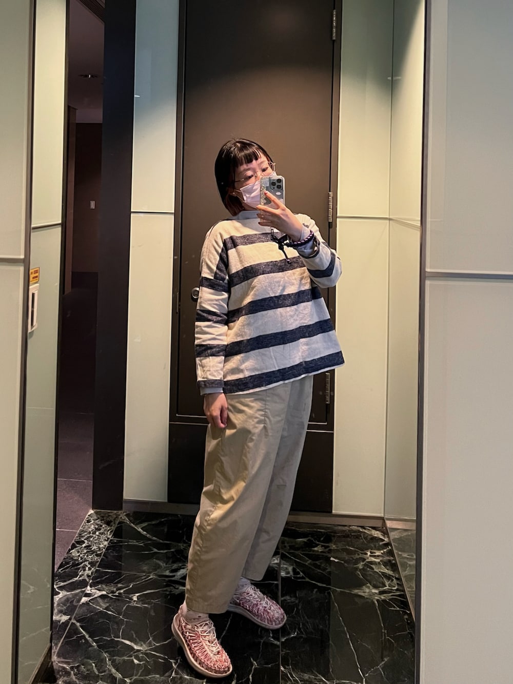 ピンク系のサンダル、ベージュ系のパンツ、ホワイト系のトップスを着用したレディースの冬コーディネートの2枚目の写真