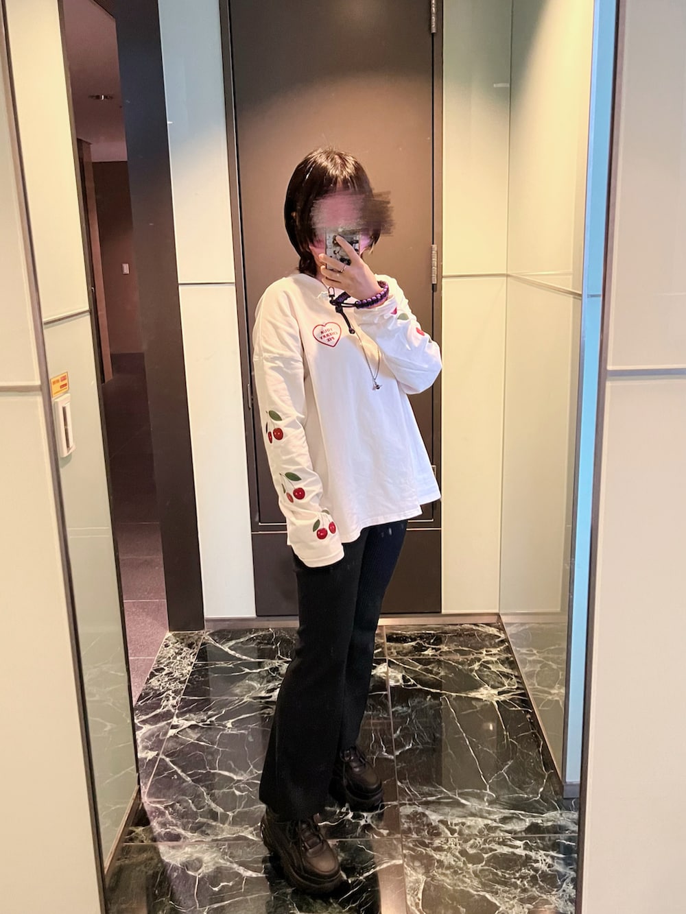 ホワイト系のトップス、ブラック系のチノパンツ、ブラック系のシューズを着用したレディースの冬コーディネートの2枚目の写真